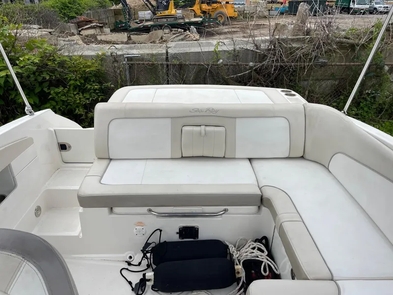 Slide: The Image of 2013 Sea Ray 240 Sundeck boat interior with white seating and storage compartments. - 14