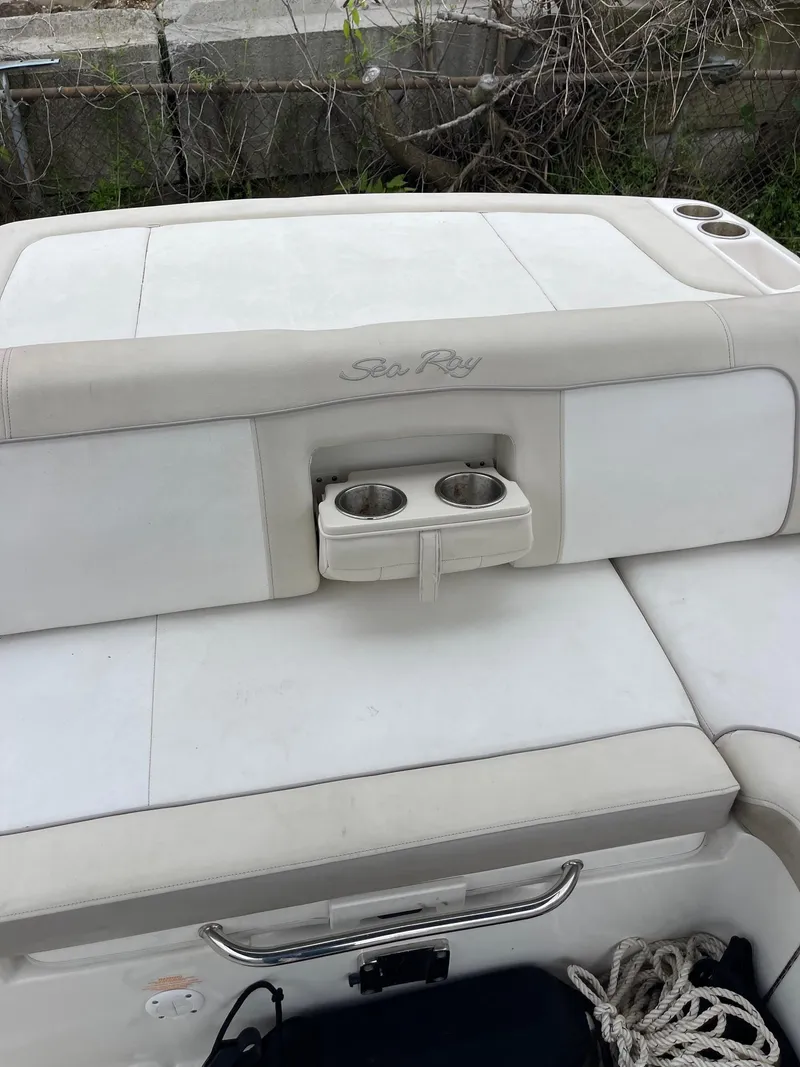 Slide: The Image of 2013 Sea Ray 240 Sundeck boat interior with cup holders and seating. - 15