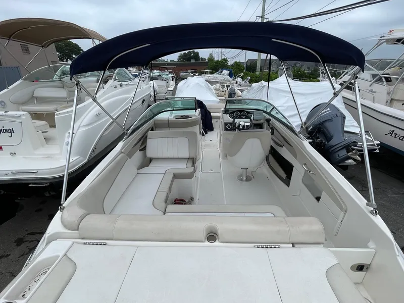 Slide: The Image of 2013 Sea Ray 240 Sundeck boat with blue canopy, spacious seating, and sleek design. - 18
