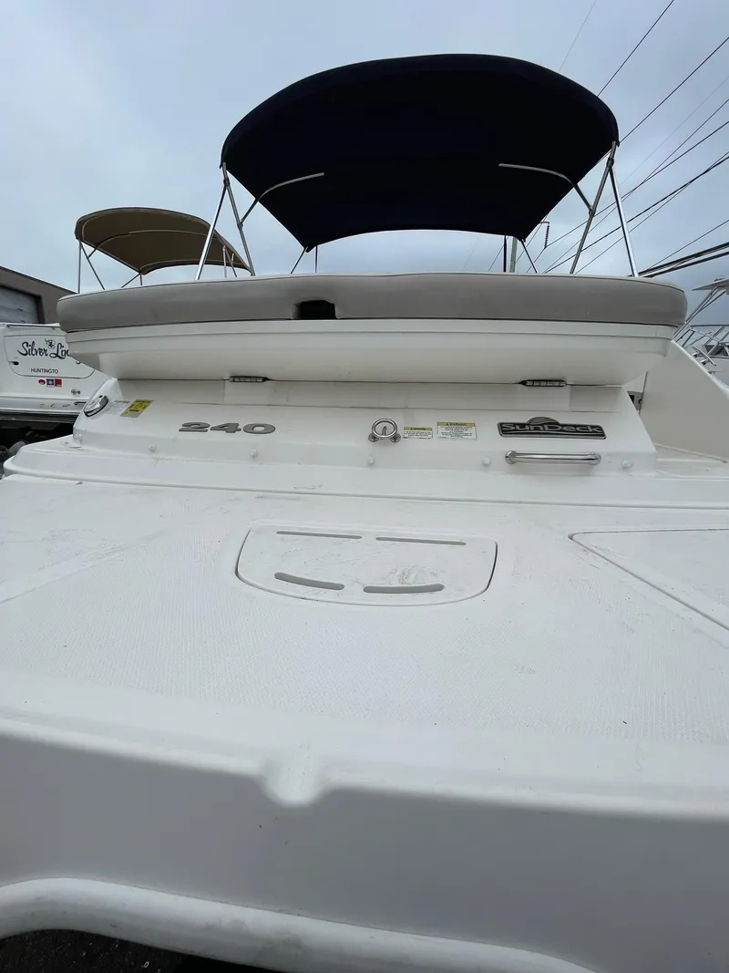 Slide: The Image of 2013 Sea Ray 240 Sundeck boat with canopy, viewed from the rear. - 19