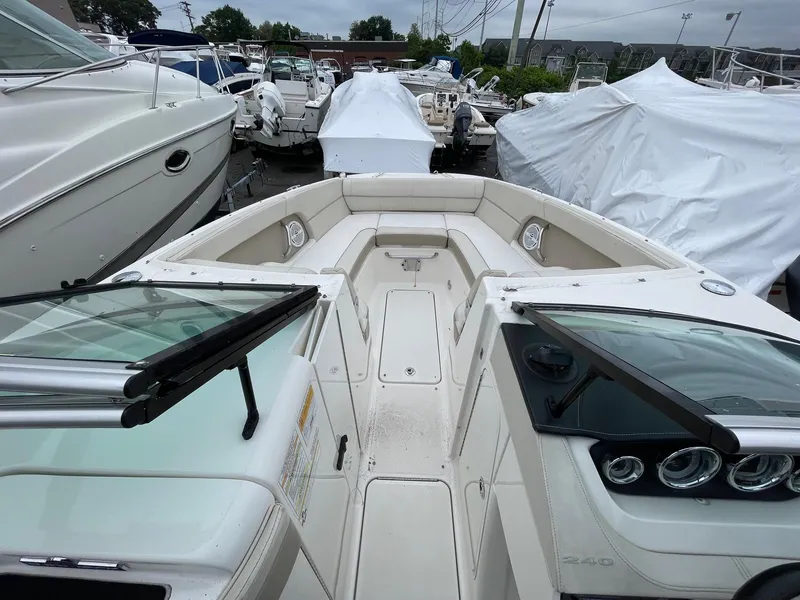 Slide: The Image of 2013 Sea Ray 240 Sundeck boat with open bow seating, docked among other boats. - 4
