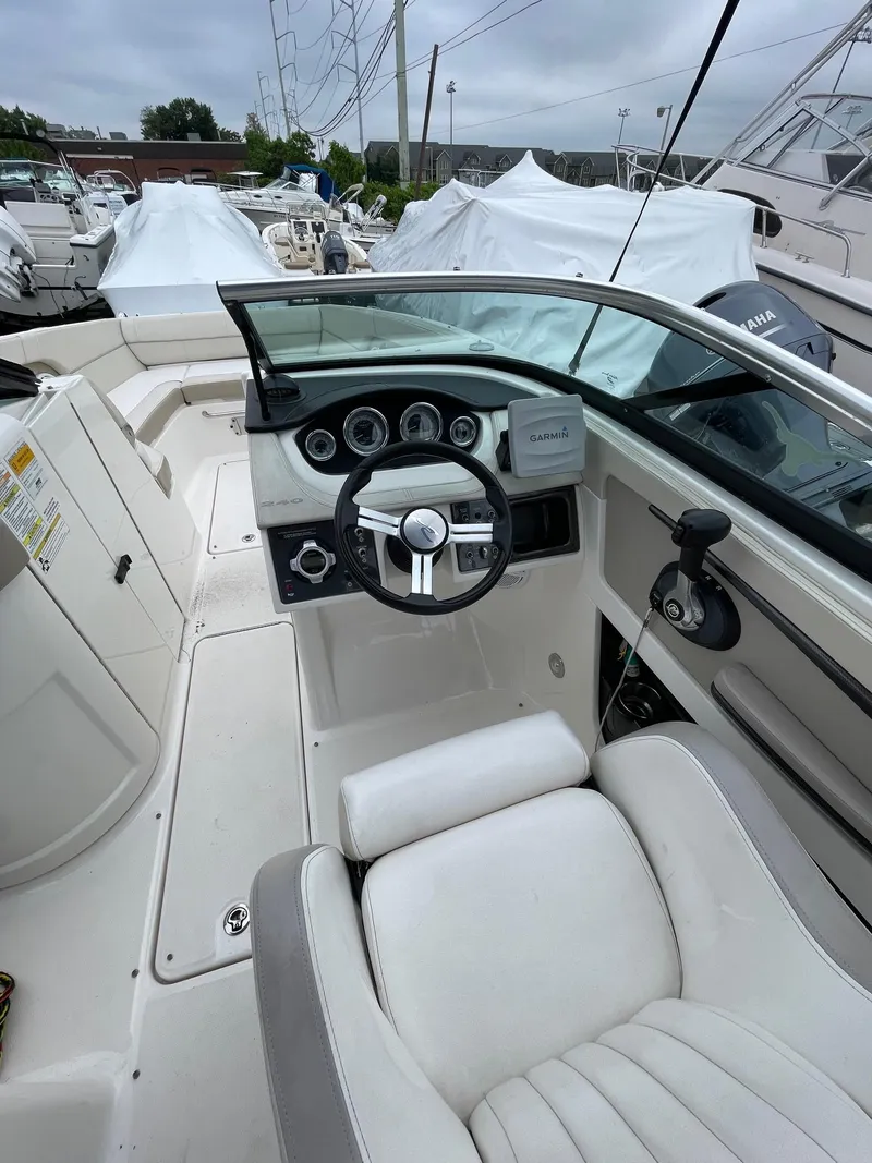 Slide: The Image of 2013 Sea Ray 240 Sundeck boat cockpit with steering wheel and dashboard controls. - 8