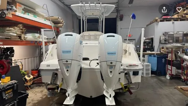 Slide: The Image of 2018 Robalo R242 Explorer boat with dual outboard engines in a workshop setting. - 6