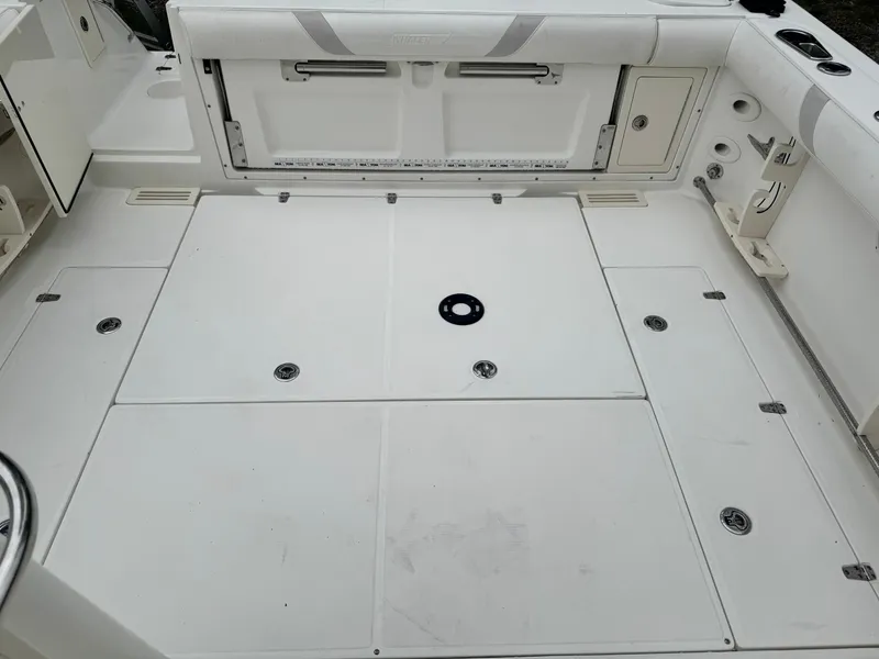 Slide: The Image of 2011 Boston Whaler 305 Conquest boat deck, featuring storage compartments and clean white surface. - 11