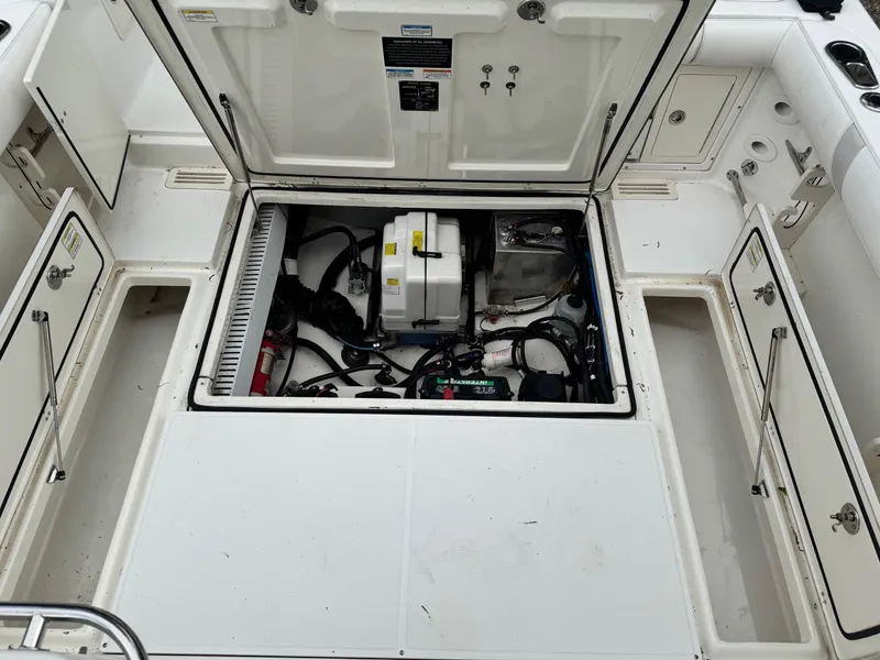 Slide: The Image of Open engine compartment of a 2011 Boston Whaler 305 Conquest boat, showing internal components. - 12
