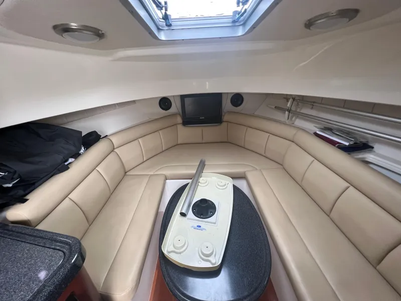 Slide: The Image of Interior of 2011 Boston Whaler 305 Conquest with beige seating and skylight. - 15