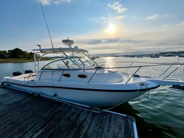 Slide: The Image of 2011 Boston Whaler 305 Conquest docked at sunset, calm waters, scenic view. - 5