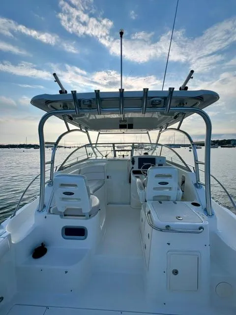 Slide: The Image of 2011 Boston Whaler 305 Conquest boat interior with seating and helm, under a clear sky. - 7