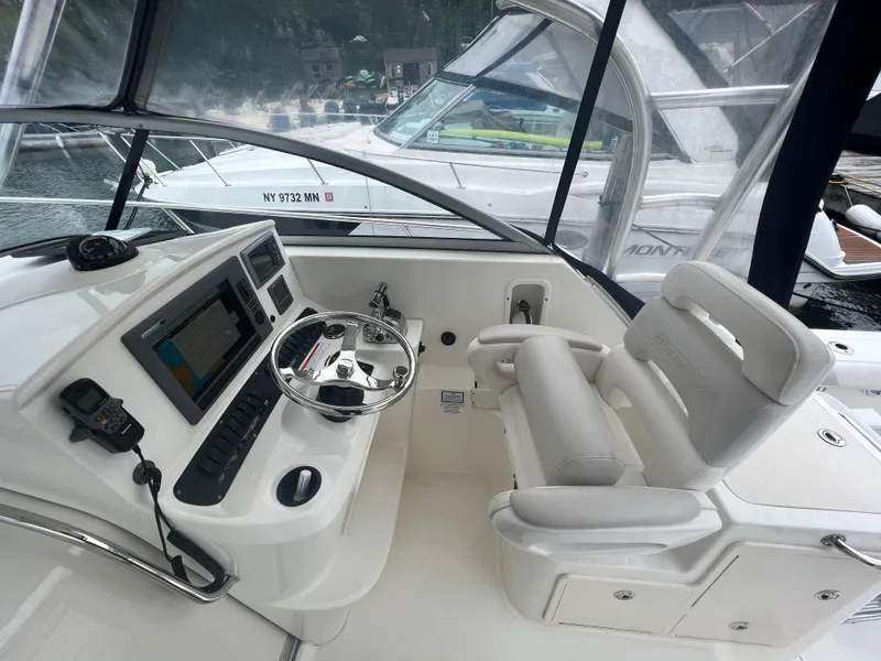 Slide: The Image of 2011 Boston Whaler 305 Conquest helm with steering wheel and navigation equipment. - 9