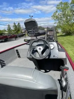 Slide: The Image of 2020 Bass Tracker Classic XL boat interior with steering wheel and dashboard, under a clear blue sky. - 4