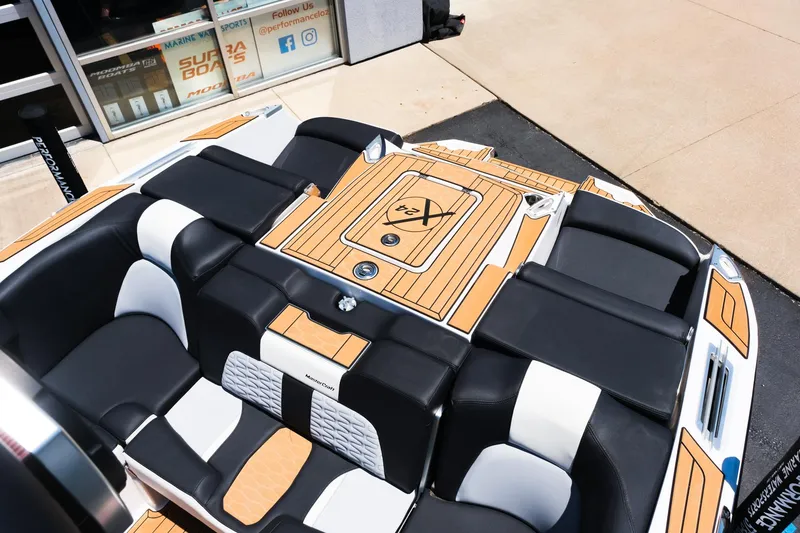 Slide: The Image of 2023 MasterCraft X24 boat interior with black and white seating and teak flooring. - 13