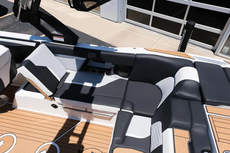 Slide: The Image of 2023 MasterCraft X24 boat interior with sleek black and white seating and teak flooring. - 15