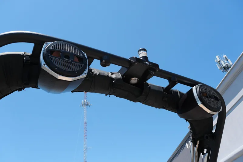 Slide: The Image of 2023 MasterCraft X24 boat speakers on a wakeboard tower against a clear blue sky. - 23