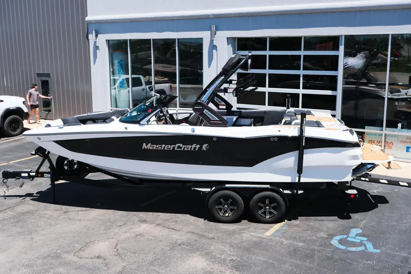 Slide: The Image of 2023 MasterCraft X24 boat on trailer outside a showroom. - 3