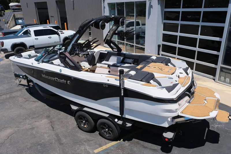 Slide: The Image of 2023 MasterCraft X24 boat on trailer, parked outside a garage. - 4