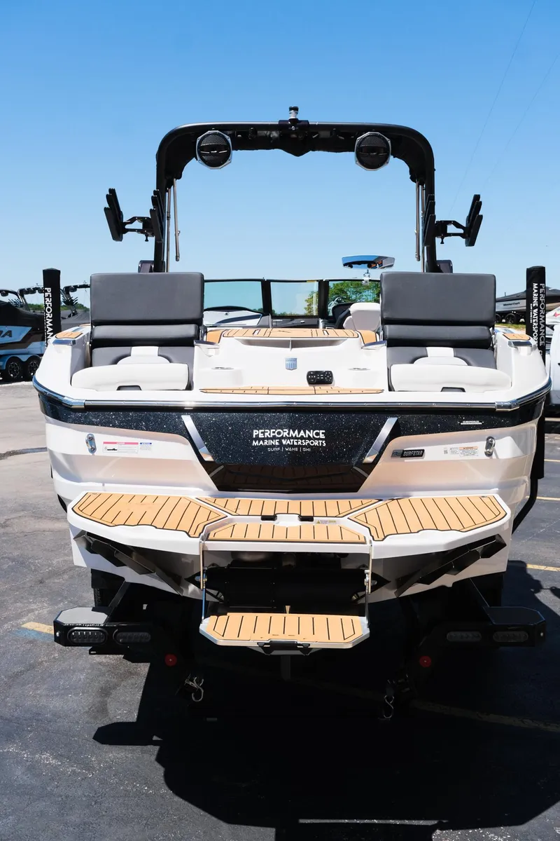 Slide: The Image of 2023 MasterCraft X24 boat with teak deck, rear view, in a parking lot. - 6