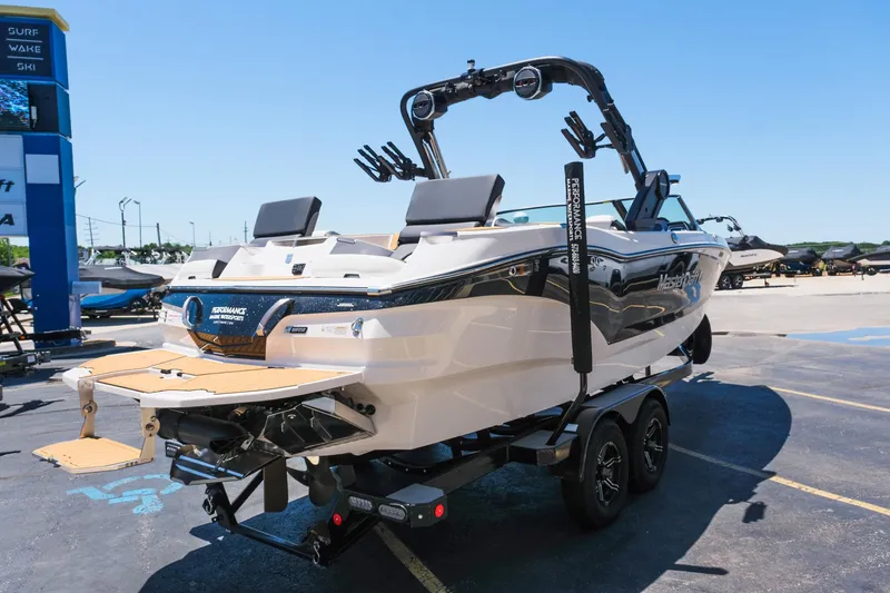 Slide: The Image of 2023 MasterCraft X24 boat on trailer, parked outdoors, showcasing sleek design and modern features. - 8