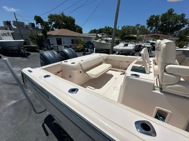 Slide: The Image of 2013 Grady-White Canyon 306 boat with spacious seating and dual engines in a marina setting. - 13
