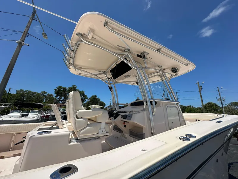 Slide: The Image of 2013 Grady-White Canyon 306 boat with T-top, viewed from the deck under a clear blue sky. - 14