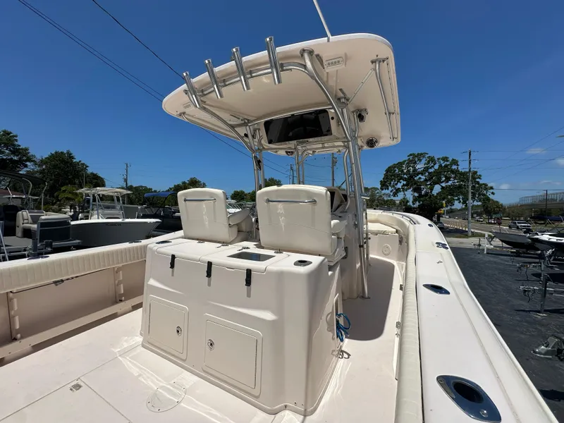 Slide: The Image of 2013 Grady-White Canyon 306 boat with center console and T-top in a marina setting. - 17