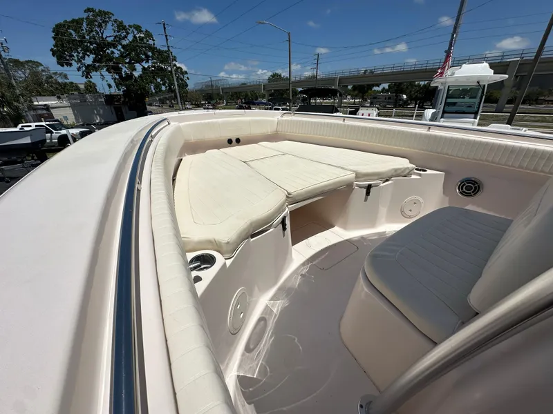 Slide: The Image of 2013 Grady-White Canyon 306 boat interior with cushioned seating and storage compartments. - 18