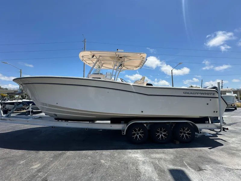 Slide: The Image of 2013 Grady-White Canyon 306 boat on a trailer under a clear blue sky. - 2