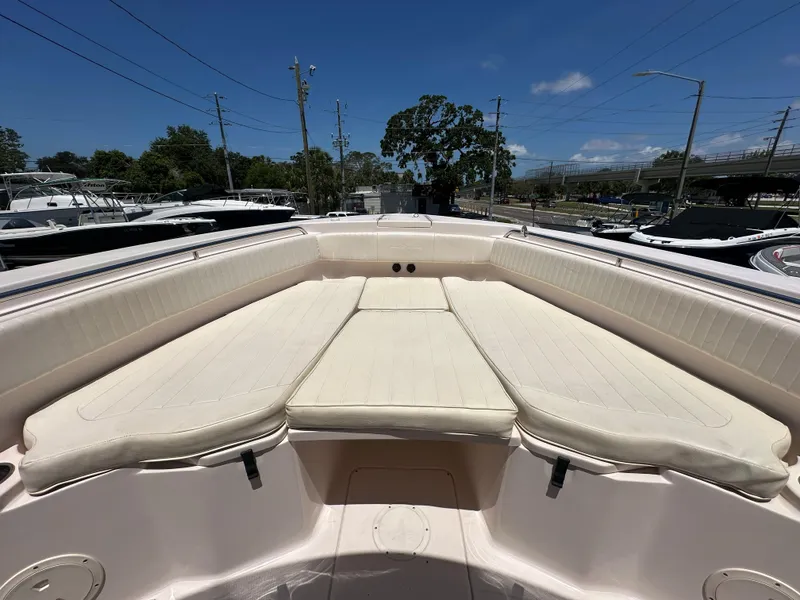 Slide: The Image of 2013 Grady-White Canyon 306 boat with spacious cushioned seating under a clear blue sky. - 20