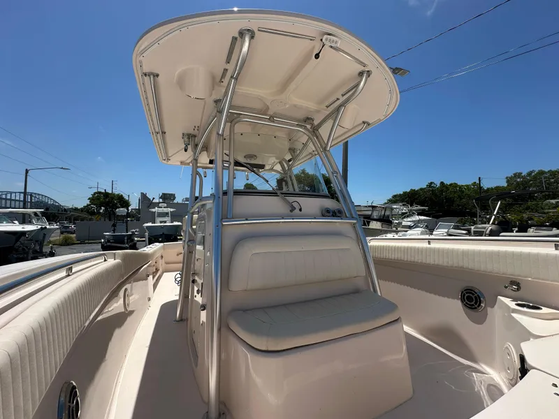 Slide: The Image of 2013 Grady-White Canyon 306 boat interior with seating and console under clear blue sky. - 23