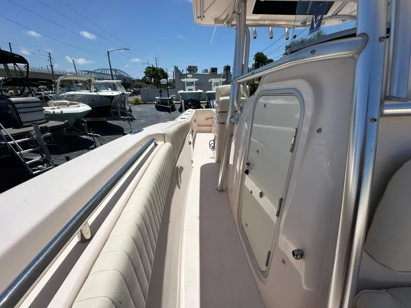 Slide: The Image of 2013 Grady-White Canyon 306 boat interior with seating and storage, docked outdoors. - 26