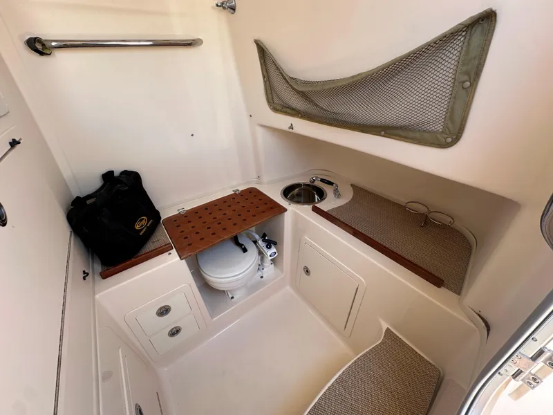 Slide: The Image of 2013 Grady-White Canyon 306 boat interior with toilet, sink, and storage. - 27