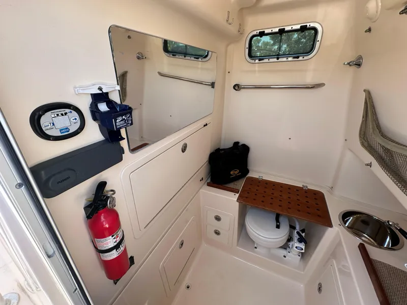 Slide: The Image of 2013 Grady-White Canyon 306 boat interior with toilet, sink, and fire extinguisher. - 28