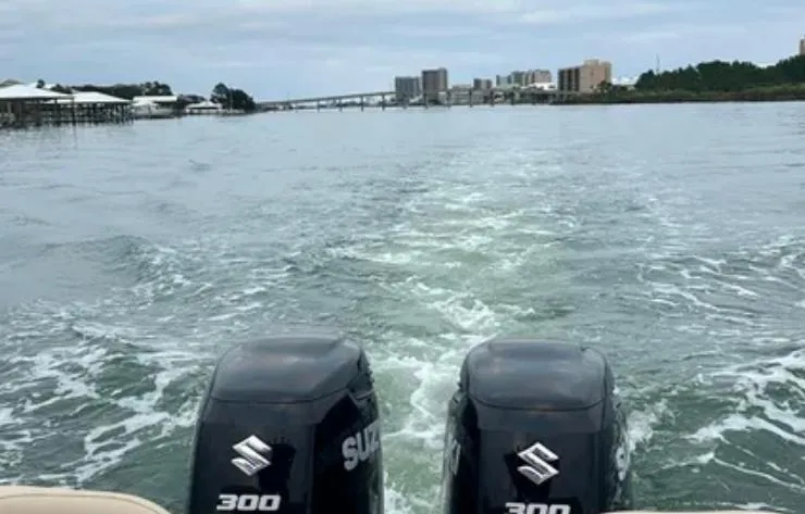 Slide: The Image of Twin Suzuki 300 engines on a 2020 Key West 263 FS boat cruising on a calm waterway. - 13