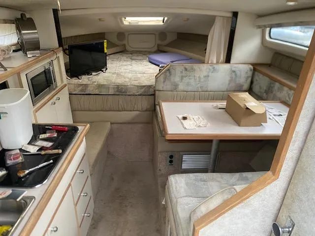 Slide: The Image of Interior of 1998 Bayliner Ciara 2855 boat with kitchenette and seating area. - 11