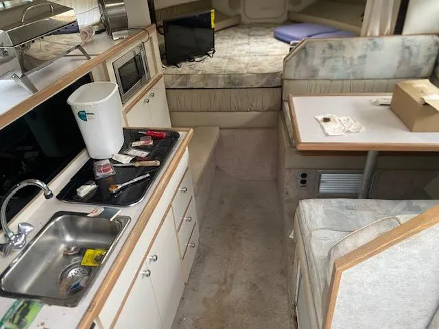 Slide: The Image of Interior of a 1998 Bayliner Ciara 2855 boat with kitchen and seating area. - 2