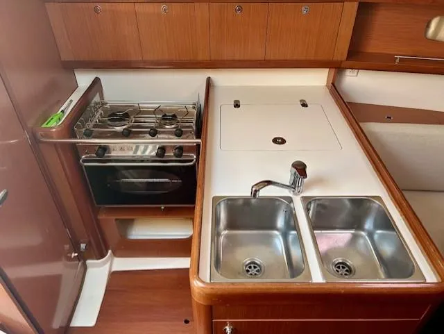Slide: The Image of Galley kitchen in 2008 Beneteau Oceanis 31 sailboat with stove, oven, and double sink. - 21
