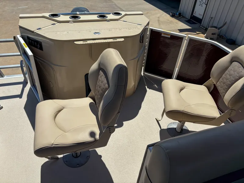 Slide: The Image of 2019 Sweetwater 2186 FS boat interior with beige seats and control panel. - 10