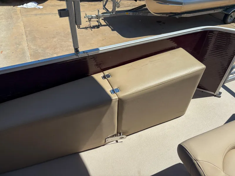 Slide: The Image of 2019 Sweetwater 2186 FS boat interior with beige seating and storage compartment. - 11