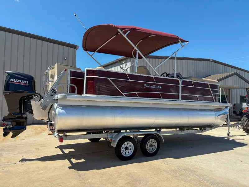 Slide: The Image of 2019 Sweetwater 2186 FS pontoon boat with maroon canopy and Suzuki outboard motor. - 2