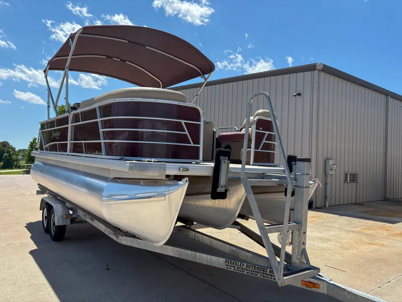 Slide: The Image of 2019 Sweetwater 2186 FS pontoon boat on trailer, parked outdoors under blue sky. - 3