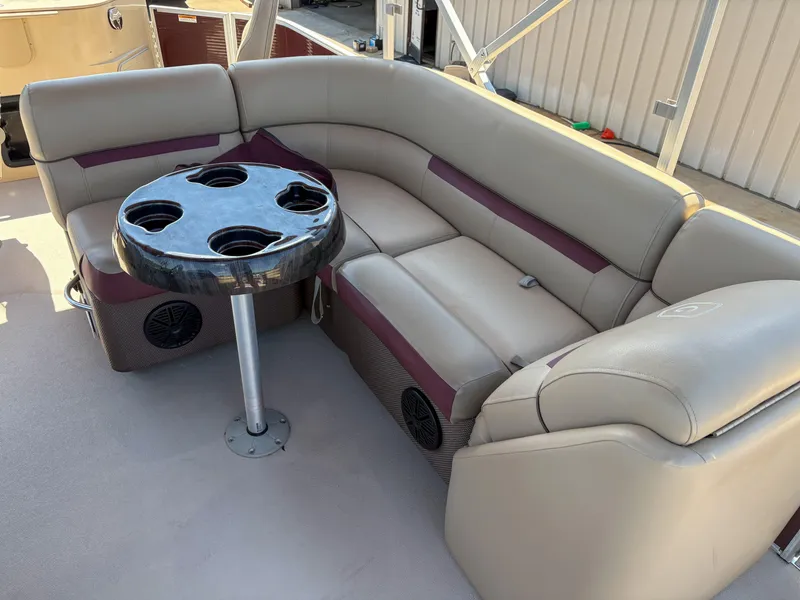 Slide: The Image of 2019 Sweetwater 2186 FS boat interior with beige seating and cupholder table. - 6