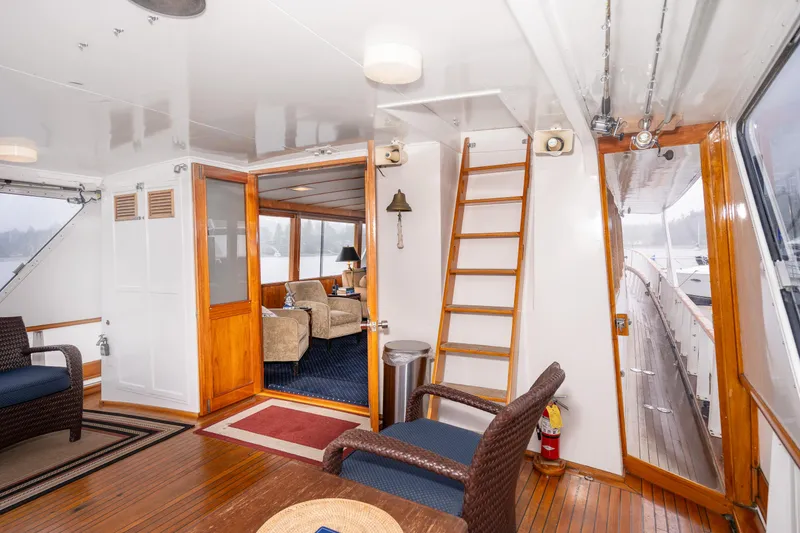 Slide: The Image of 1980 McQueen Motoryacht interior with wooden accents, seating area, and ladder access. - 13