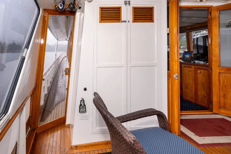 Slide: The Image of 1980 McQueen Motoryacht interior with wooden accents and wicker chair. - 17