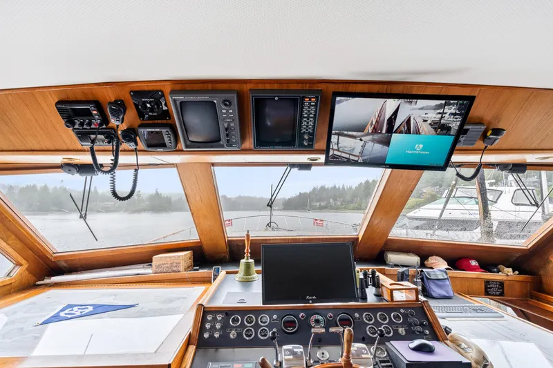 Slide: The Image of 1980 McQueen Motoryacht helm with navigation equipment and scenic waterway view. - 28