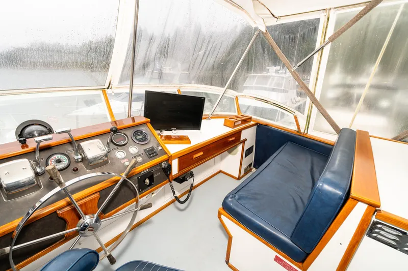 Slide: The Image of 1980 McQueen Motoryacht helm with steering wheel, gauges, and blue seating. - 41