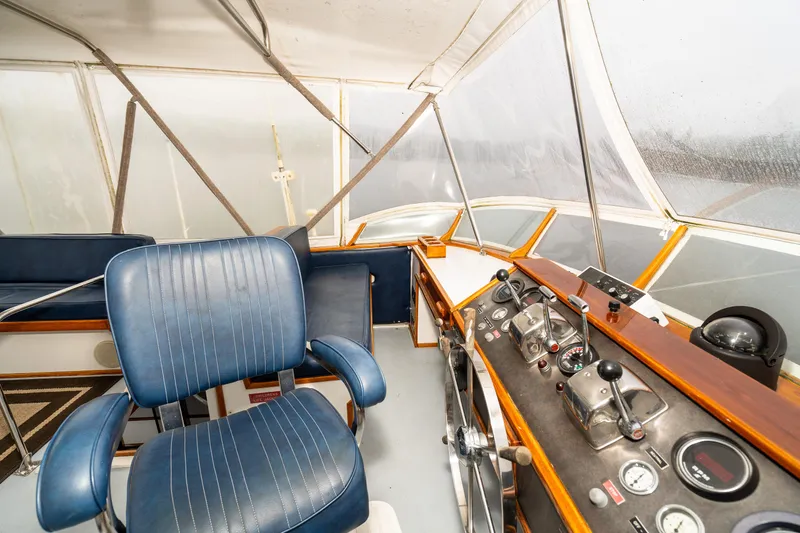 Slide: The Image of Interior of a 1980 McQueen Motoryacht cockpit with blue seating and control panel. - 42