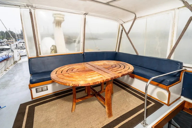 Slide: The Image of 1980 McQueen Motoryacht interior with wooden table and blue seating. - 46