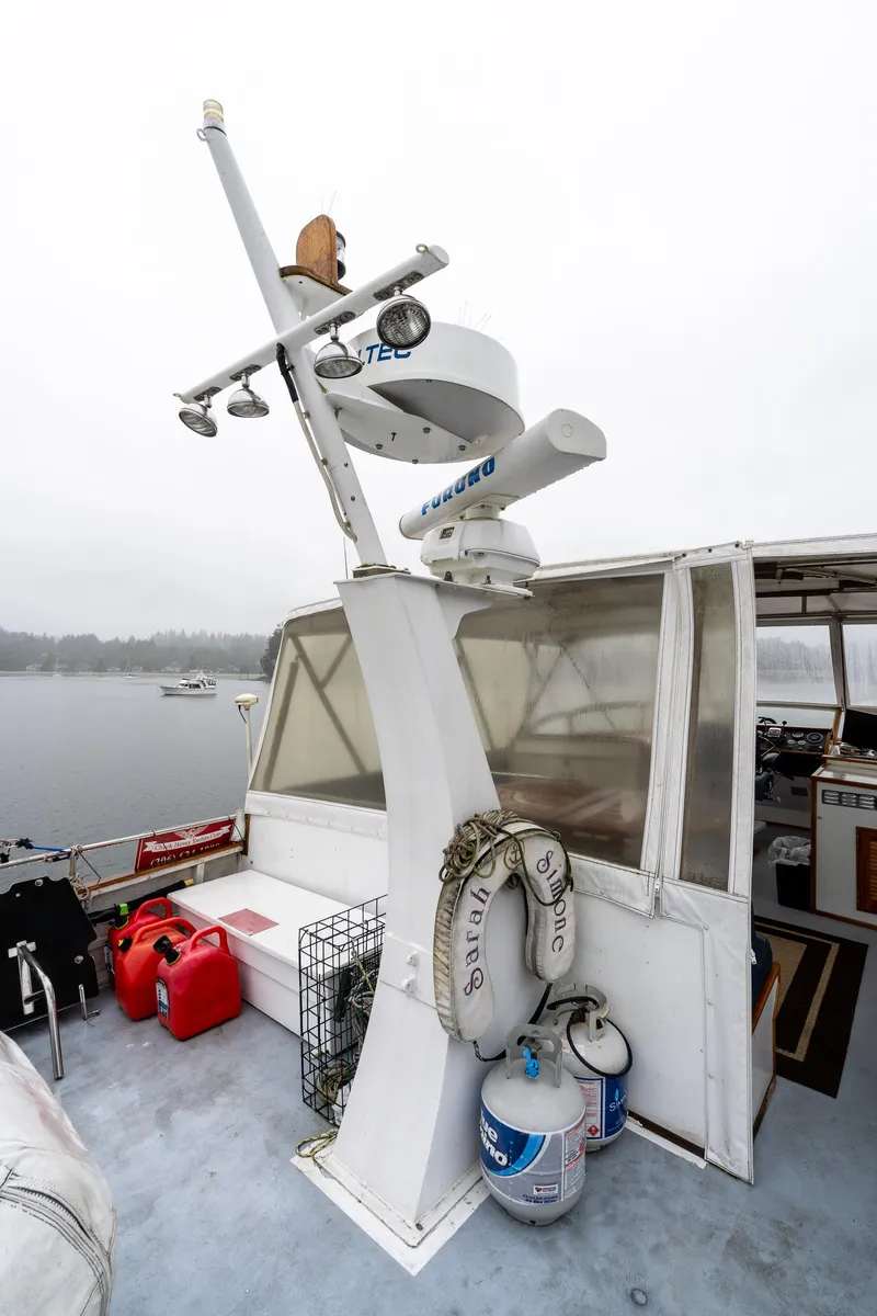 Slide: The Image of 1980 McQueen Motoryacht deck with radar, life rings, and gas canisters. - 49