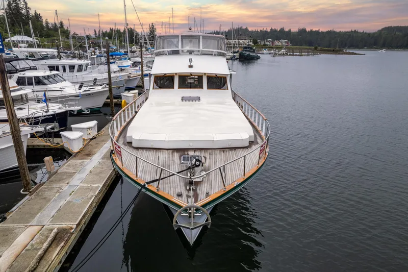 Slide: The Image of 1980 McQueen Motoryacht docked at marina during sunset, surrounded by other boats. - 6