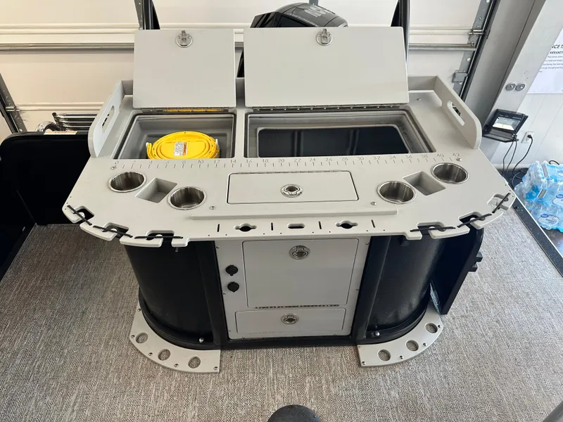 Slide: The Image of 2025 Premier Sunsation 230 Angler boat console with storage, cup holders, and utility compartments. - 11