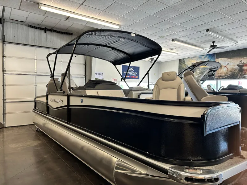 Slide: The Image of 2025 Premier Sunsation 230 Angler pontoon boat displayed indoors with canopy and seating. - 4